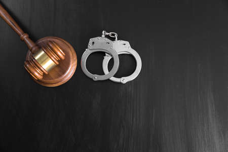 Gavel and handcuffs on table backgroundの写真素材