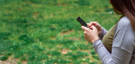 Hands using mobile phone in spring natureの写真素材