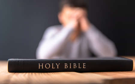 prayer man with Holy Bible on wooden backgroundの写真素材