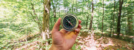 man holding compass on the forest backgroundの写真素材