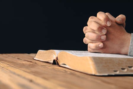 prayer man holding cross with Holy Bible