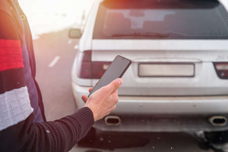 Man standing next to the car. man using smartphone
