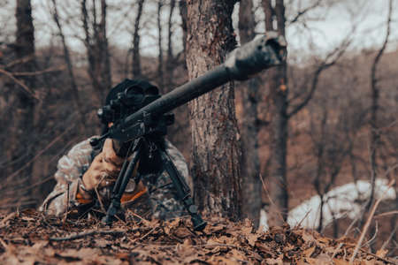 soldiers holding gun crouched and ambushed in the forest
