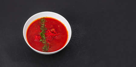 Red borscht - clear beetroot soup on black tableの写真素材