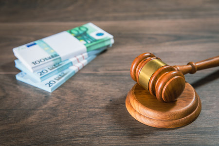 Lawyer and attorney concept. Wooden judge gavel and dollars on the table.の写真素材