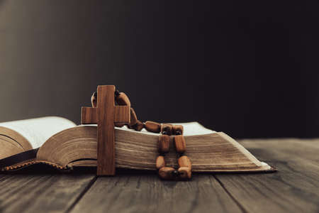 Holy Bible with wooden cross on the table