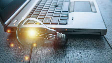 idea concept, light bulb with computer on table