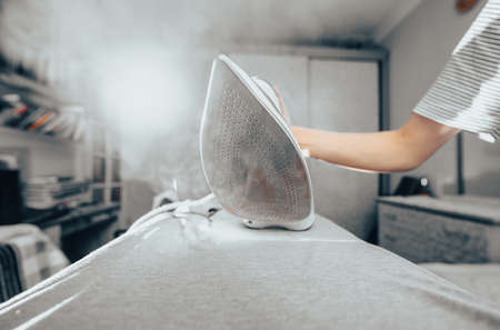 close up hand of woman ironing clothes on the tableの写真素材