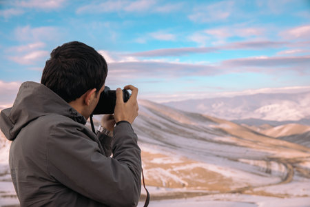 photographer takes a photo of the beautiful mountain landscapeの写真素材