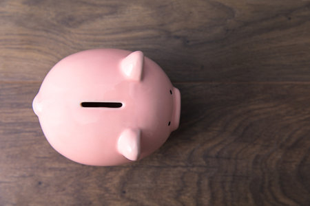 Pink Piggy bank on wooden table backgroundの写真素材