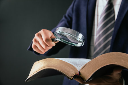 man reading book with magnifierの写真素材