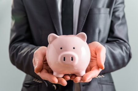 Young business man with piggy bankの写真素材