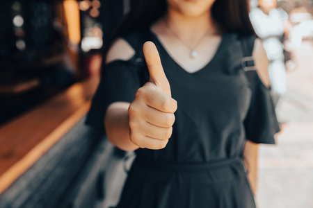 business woman shows thumb up in streetの写真素材