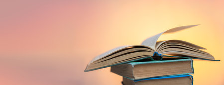 Open book on books on orange backgroundの写真素材
