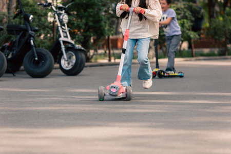 Little girl playing with a scooter in the cityの写真素材