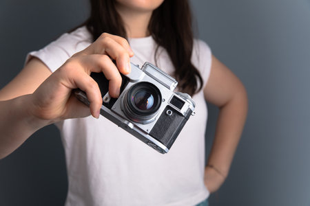 Girl holding an old vintage camera in her handの写真素材