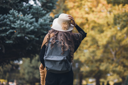 Girl in a hat with a backpack in the forestの写真素材