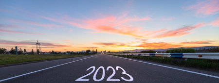 Asphalt road and inscription 2023 at sunsetの写真素材