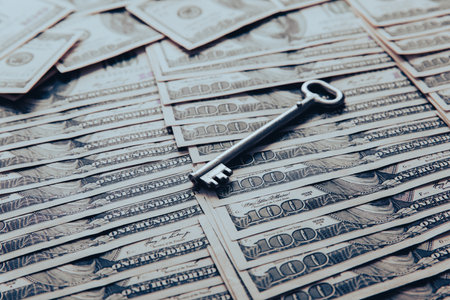 Dollar bills and steel key on the tableの写真素材