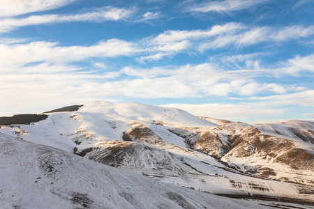 The mountain is covered with snow under the cloudsの写真素材