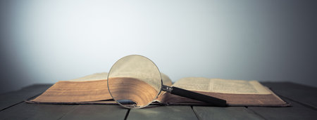 Book and magnifying glass on the tableの写真素材