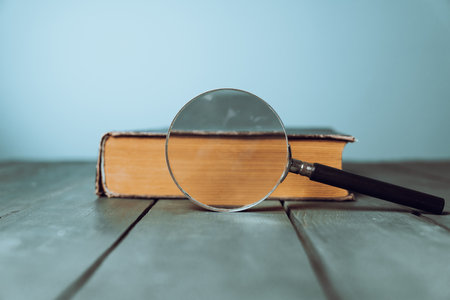 Book and magnifying glass on the tableの写真素材