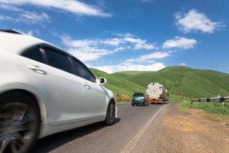 Cars drive on an asphalt road during the dayの写真素材