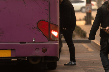 People get on the bus at the bus stop in the eveningの写真素材