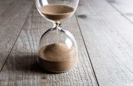 Hourglass on a wooden tableの写真素材