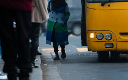 People and the bus stand at the bus stop during the dayの写真素材