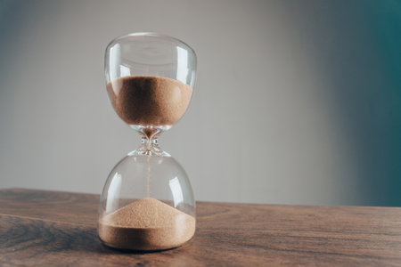 Hourglass on a wooden tableの写真素材