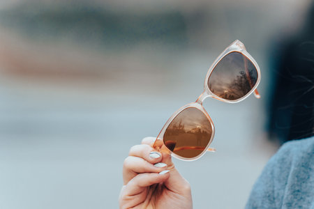 woman holding sunglasses in her handの写真素材