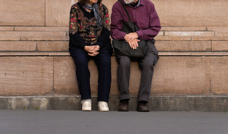 Elderly couple sitting together outdoorsの写真素材