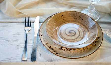 Ceramic dishes and cutlery on the tableの写真素材
