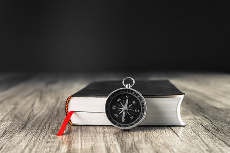 Book and compass on the table. concept direction world viewの写真素材