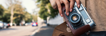 young woman holding vintage camera in the streetの写真素材