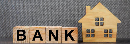 real estate concept, house model and bank word on cubesの写真素材