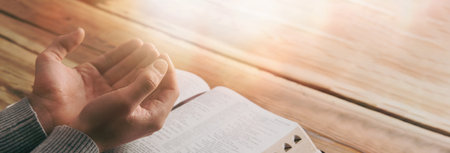 Christian hands praying with the open book