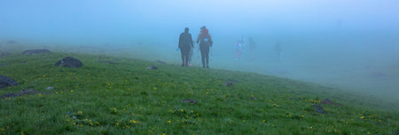 Hikers group traveling in the foggy mountain.