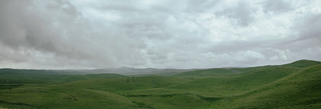 Dark heavy clouds over the green valleyの写真素材