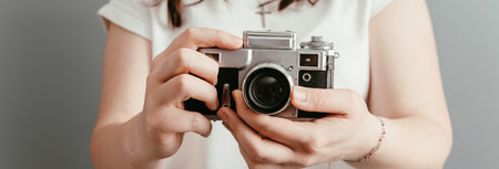 Girl holding an old vintage camera in her handの写真素材