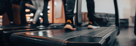 blurred image of young man and woman running on treadmills in gymの写真素材