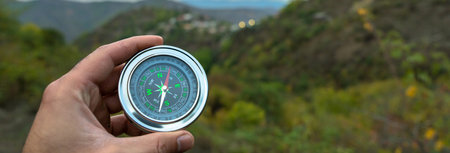 Holds a compass a against the backdrop of forests and mountainsの写真素材