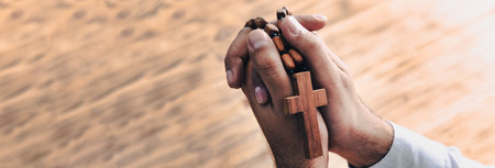 A man prays holding a cross in his hands. Christian manの写真素材