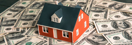 Dollar bills and house on the tableの写真素材