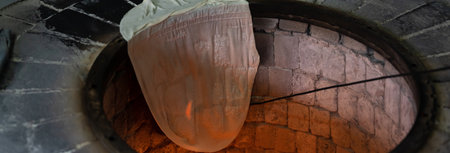 Lavash hangs on the edge of the tandoor. Bread-makingの写真素材