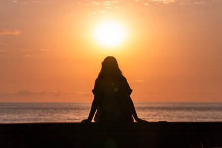 Young girl during sunset by the sea