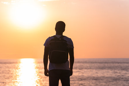 Man standing on the beach during sunsetの写真素材
