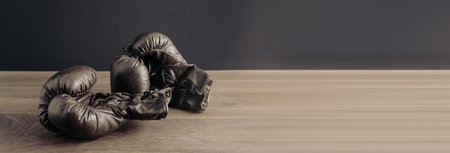 Black boxing gloves on a wooden tableの写真素材