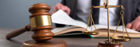 Judging reads a book in front of a hammer and scales. court roomの写真素材